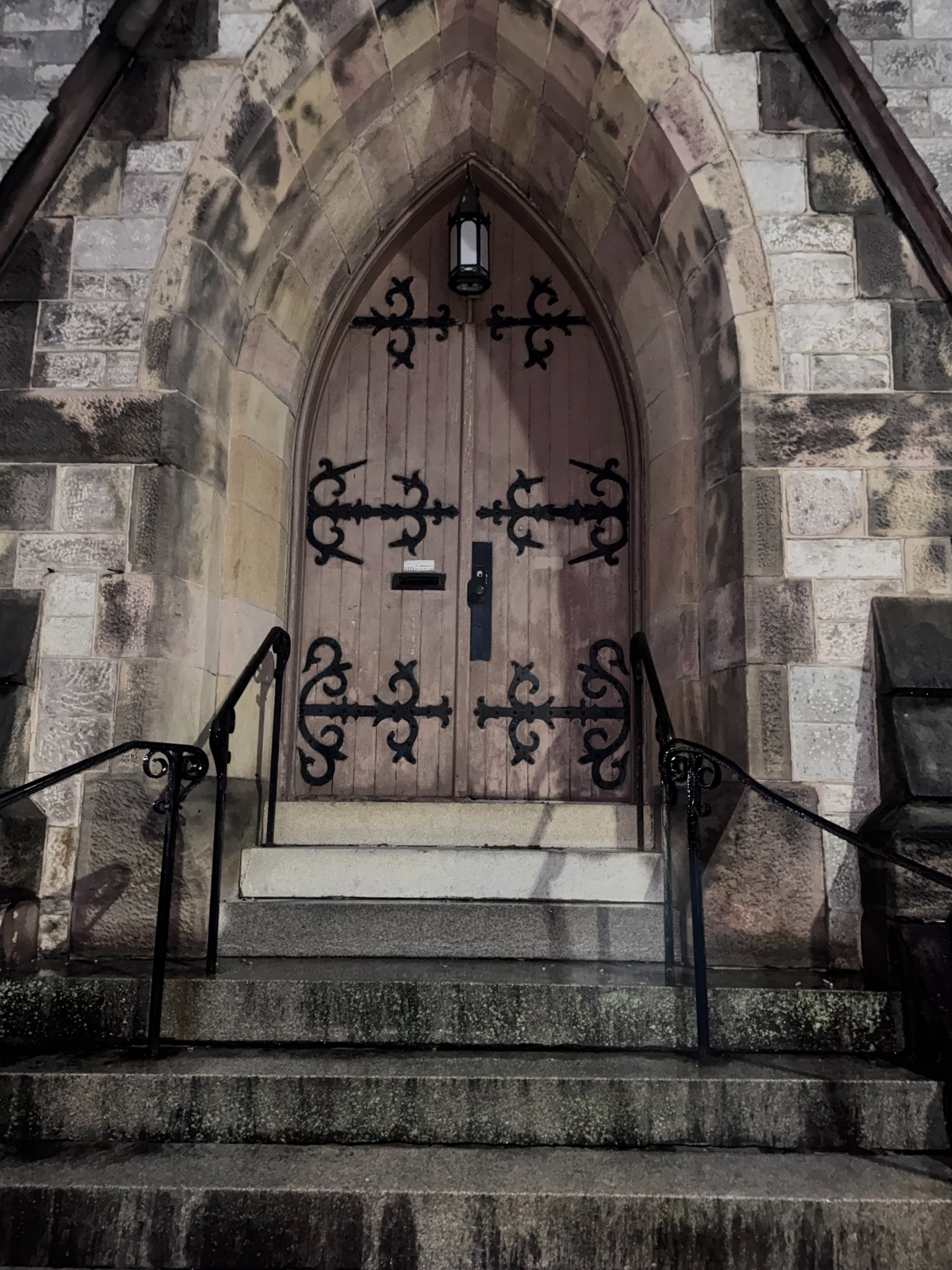 Carved wooden doorway with decorative iron hinges